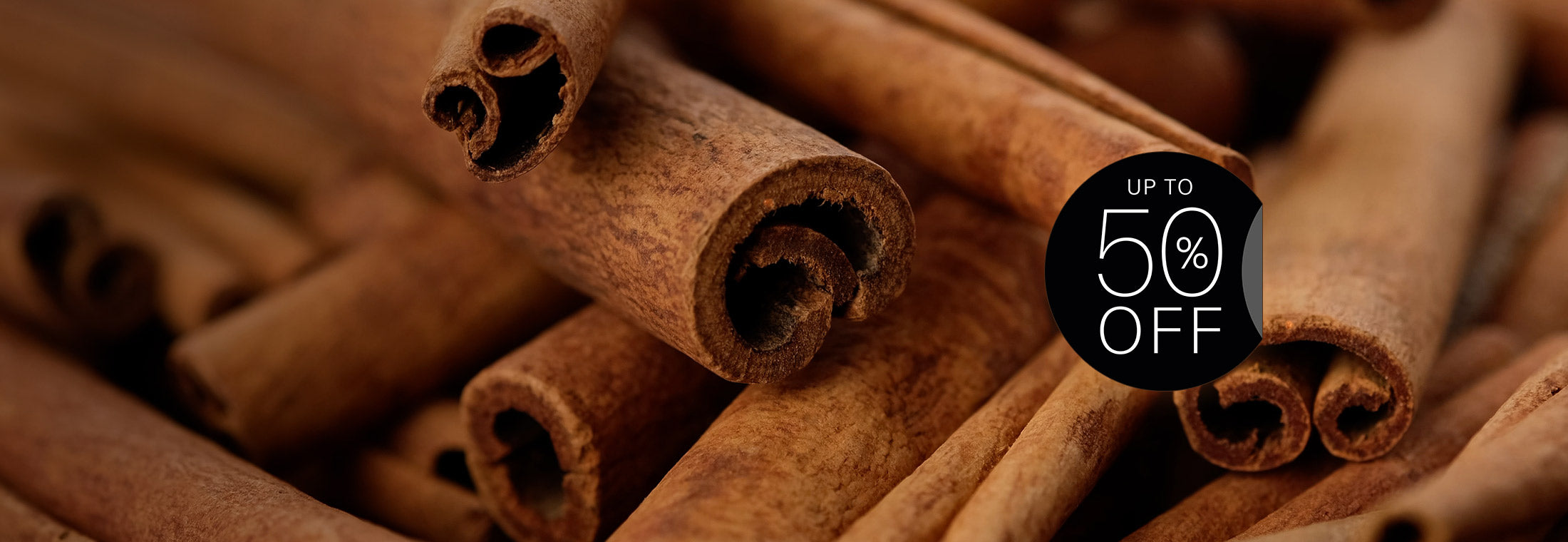Zoomed in on cinnamon sticks with a 'Up to 50% Off' discount badge